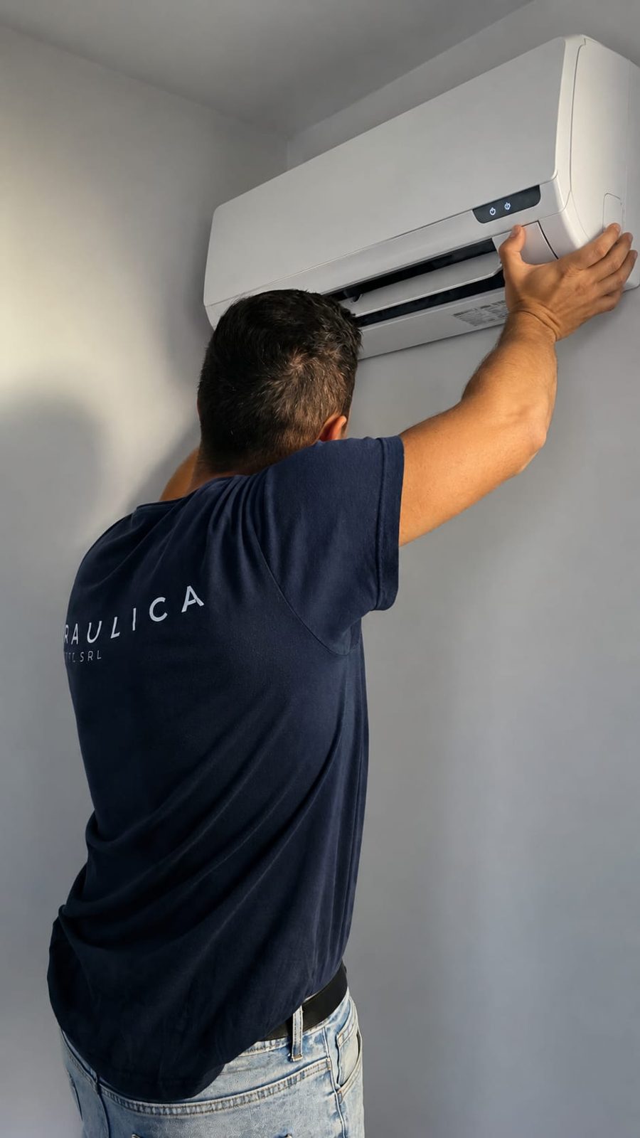 Tecnico Idraulica Diciotto durante l'installazione di un condizionatore